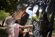 Indígena tira pichação de escultura em homenagem a Galdino