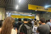 Passageiros aguardam a chuva passar para sair de estação