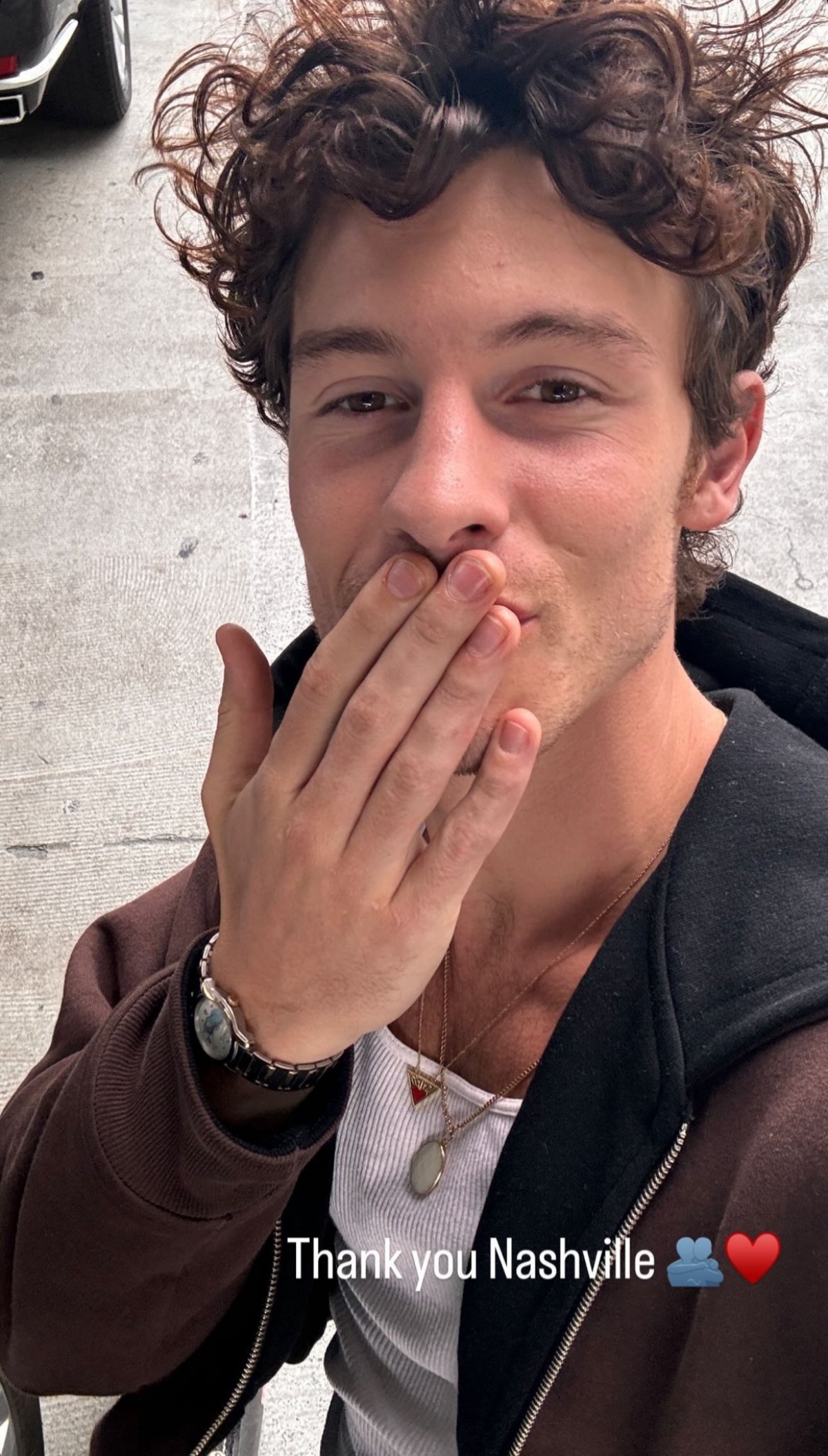 A imagem mostra o cantos Shawn Mendes mandando beijos para a camera enquanto tira uma selfie