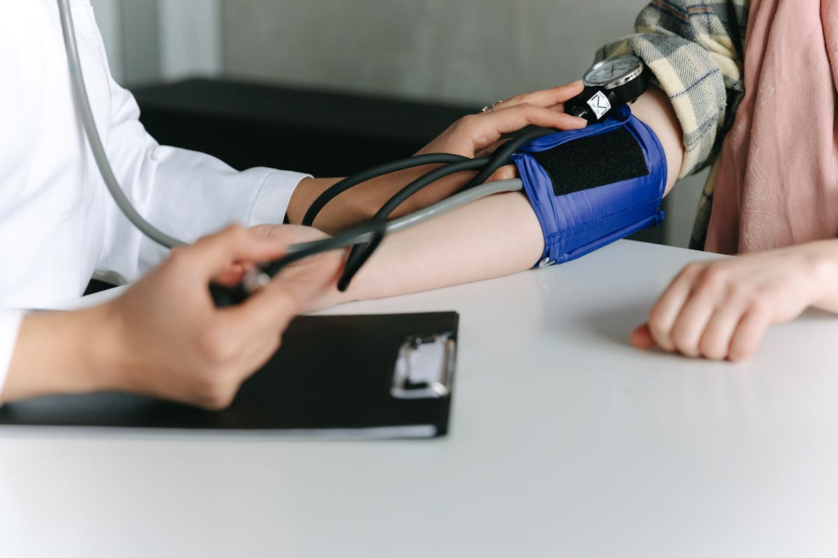 Mãos de médico medindo pressão de paciente - Metrópoles