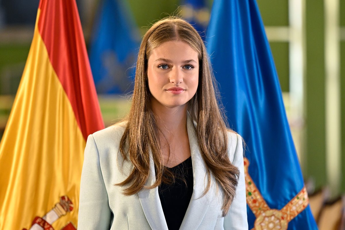 Foto colorida de mulher loira à frente de duas bandeiras, sendo uma da Espanha - Metrópoles