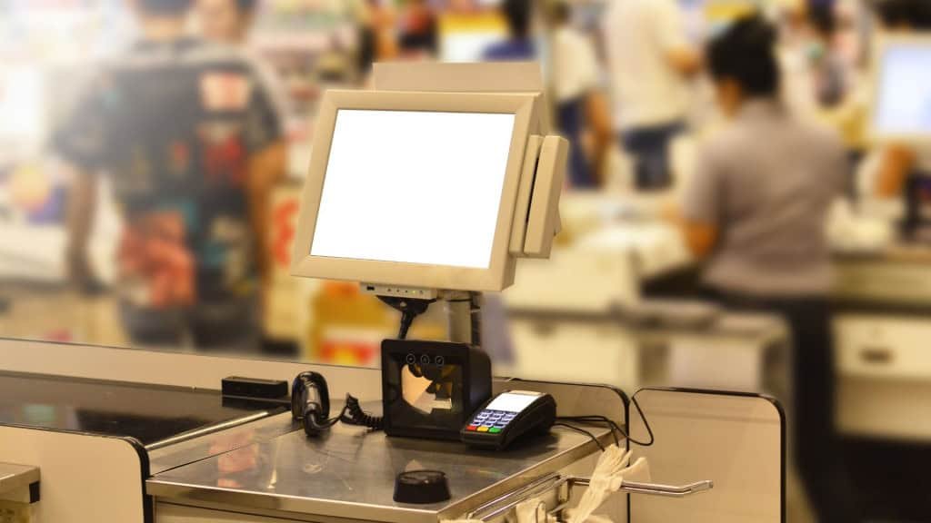 Terminal de ponto de venda (POS) na loja ou pagamento com cartão de crédito para compras com máquina EDC na loja de departamentos, com cliente e caixa desfocados ao fundo e iluminação suave.