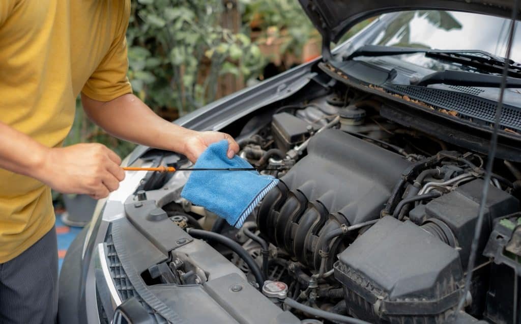 Motorista verifica o nível de óleo do carro