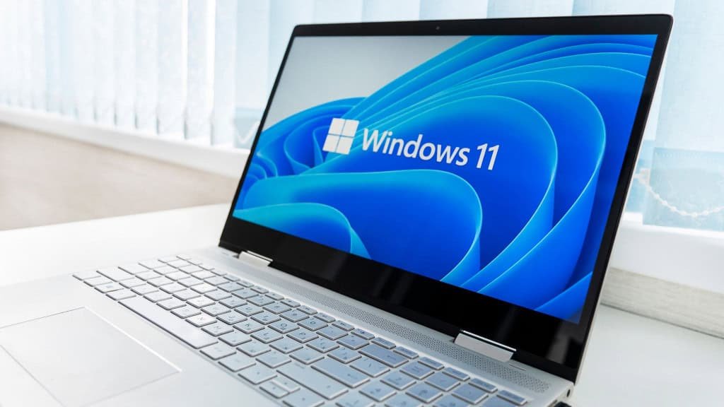 imagem mostra um notebook/laptop com teclado blanco e monitor preto, exibindo a tela do windows 11