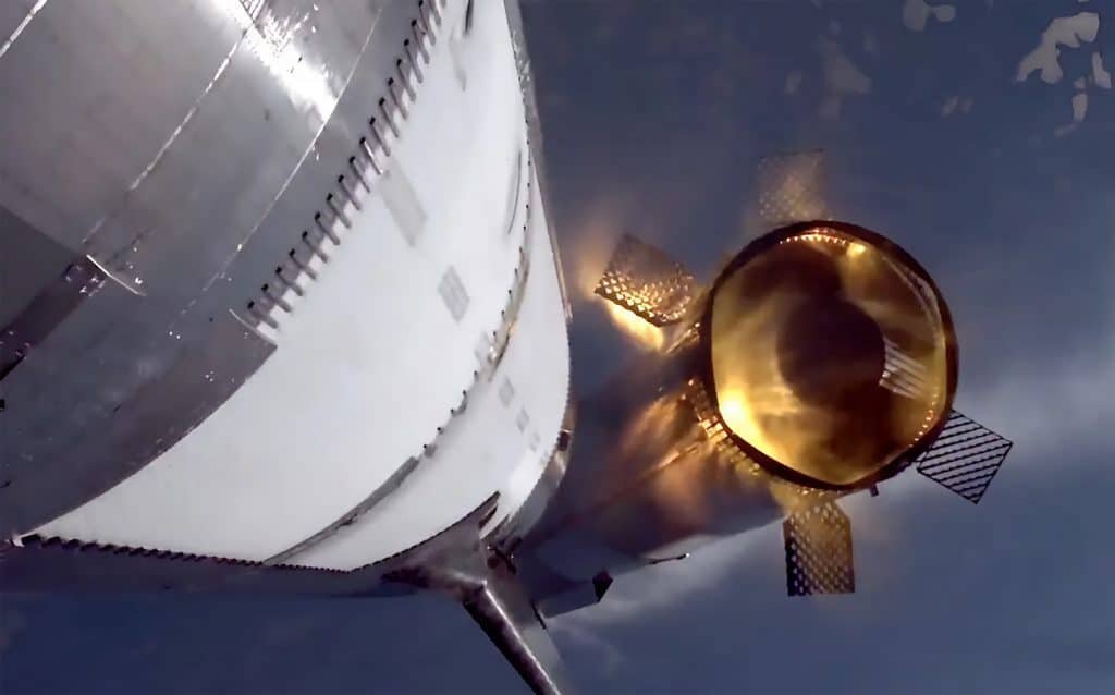 Captura de tela da transmissão ao vivo do sétimo voo de teste do Starship mostra a visão de uma câmera traseira a bordo do estágio superior. O propulsor Super Heavy, com suas quatro aletas de grade estendidas, é visto momentos após a separação dos estágios